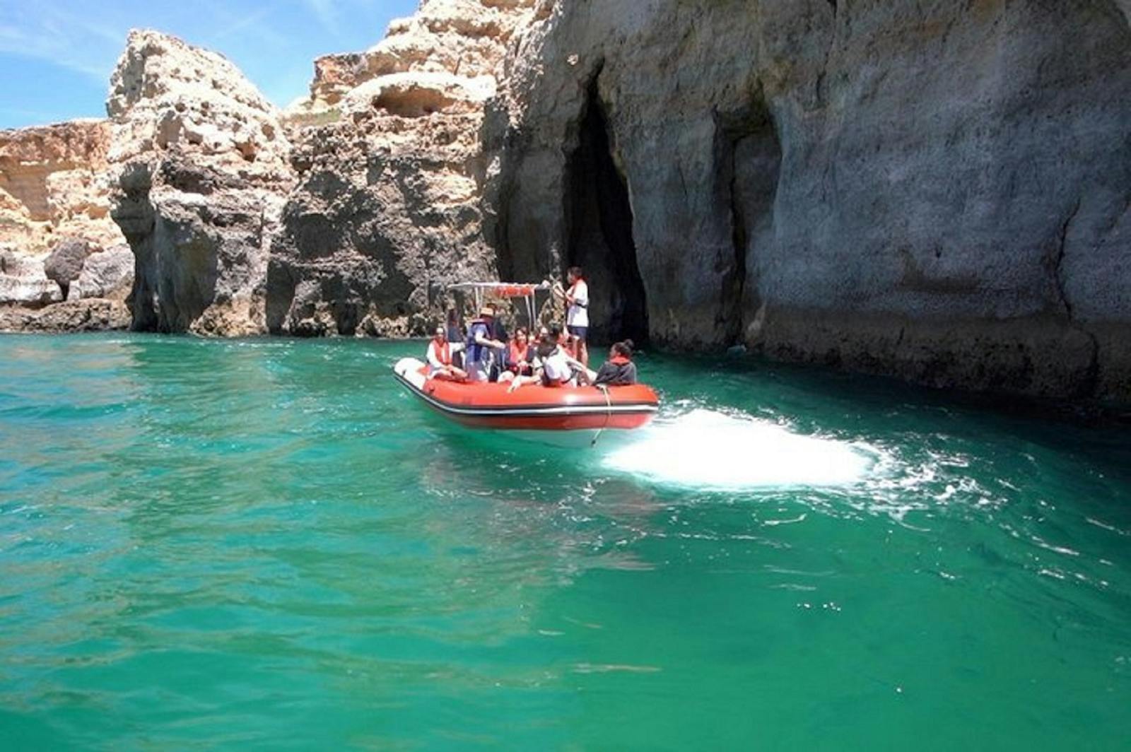 Les Grottes de Benagil vues depuis un bateau rouge